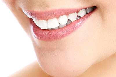 A close-up image of a person s smiling face with teeth, showcasing the dental product.