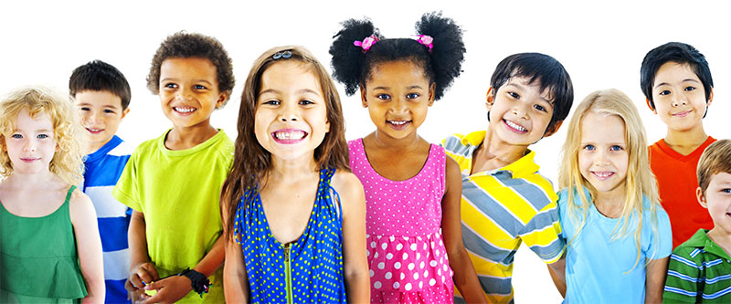 A diverse group of children and adults posing for a photo, with vibrant clothing and a cheerful atmosphere.