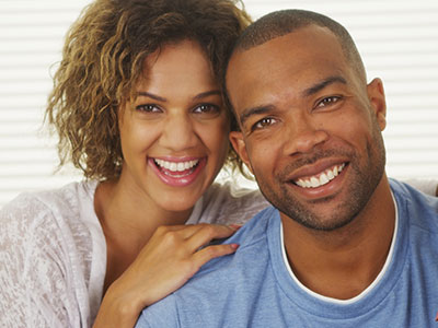 Happy couple posing for a photo with smiles.