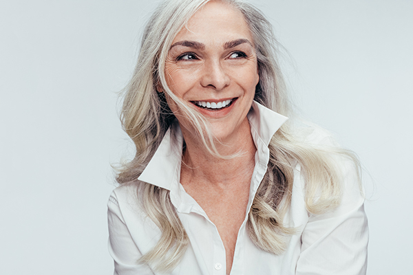 A woman with blonde hair and a white shirt smiling at the camera.